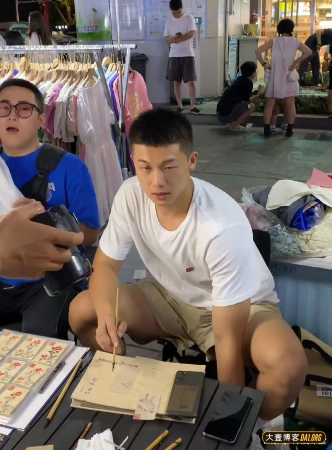 逛夜市偶遇坐在小凳子上画画的帅哥，长相乖乖地，散发着青春气息